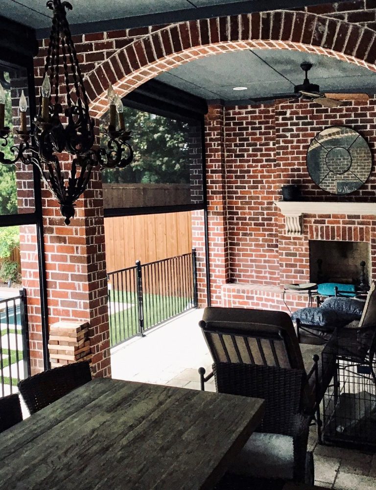 Peaceful backyard view from a cozy outdoor fireplace and dining area, perfect for relaxation and entertaining."