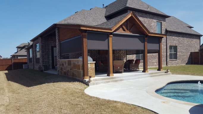 Modern Texas patio with wood accents and motorized shades, creating a stylish and functional outdoor space